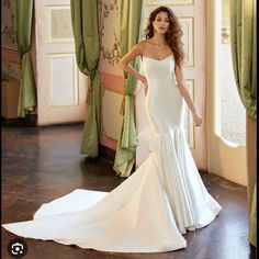 a woman in a white wedding dress posing for the camera with her hand on her hip