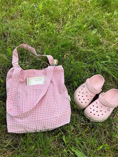 a pink and white gingham tote bag, pair of slippers on the grass