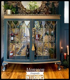 an ornate glass cabinet with candles on top