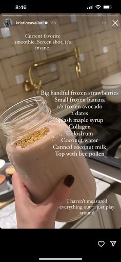 a person holding up a jar filled with food in front of a kitchen counter top