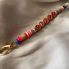 a keychain that has been decorated with colorful beads and gold metal letters on it