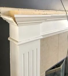 a white fireplace with a tv on top of it and wires in between the mantels