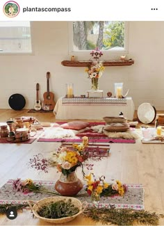 a table with flowers and candles on it in the middle of a room filled with other items