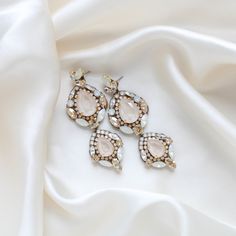 Feel like a modern-day royalty with our luxurious GIANNA statement bridal earrings. Handcrafted with dazzling Austrian crystals, the earrings make a bold and sophisticated statement. Perfect for all special occasions! PLEASE ALLOW APPROX 10 BUSINESS DAYS FOR COMPLETION BEFORE SHIPPING- Handcrafted with Austrian crystals - Each stone is set by hand in my studio- Golden shadow, ivory cream, white opal and clear stones- Antique gold finish- Earrings measure 3.25 inches x 1.125 inch- Handcrafted in the US.- Nickel free and hypoallergenicThis is an original design by © Treasures by Agnes FOR MATCHING PIECES SIMPLY TYPE "GIANNA" IN THE SEARCH BAR Statement Bridal Earrings, Crystal Statement Earrings, Bridal Statement Earrings, Golden Shadow, Search Bar, Clear Stone, Bridal Necklace, Matching Necklaces, Austrian Crystal