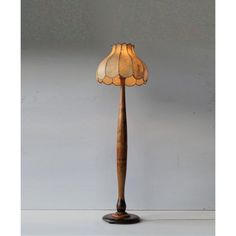 a lamp that is sitting on top of a wooden stand with a glass shade over it