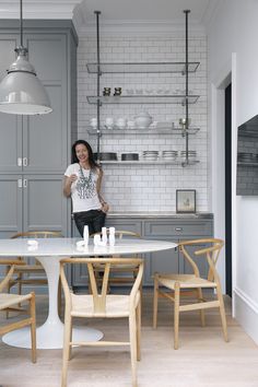 an image of a kitchen with grey cabinets and white tile on the wall above it