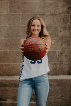 a woman holding a basketball in her hands