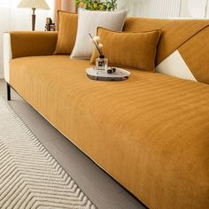 a living room with an orange couch and white rug