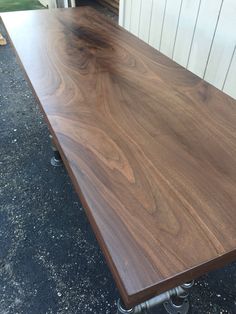 a wooden table sitting on top of a sidewalk