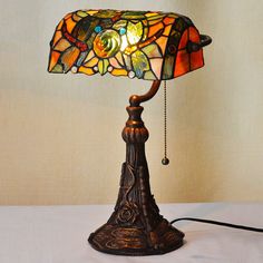 a lamp that is sitting on top of a white tablecloth and has a dragon design on it