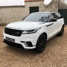 a white range rover parked in front of a building