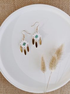 "The clay pieces are an ivory / white color in a sandpaper-like texture. The turquoise stones are authentic and the charms are brass. They are approximately 2\" in length, lightweight and handmade! *FREE EARRING BONUS*: Every order $20+ receives a free pair of earrings of the shop's choice! *FREE SHIPPING*: Use code \"FREESHIP50\" for free shipping on orders $50+. For customizations: Please feel free to message the shop. We cannot always guarantee this as an option, but it never hurts to ask. Pr White Adjustable Pierced Earrings, White Bohemian Pierced Earrings, White Bohemian Pierced Jewelry, Nickel Free White Bohemian Earrings, Nickel-free White Bohemian Earrings, Bohemian Nickel-free White Earrings, Bohemian White Nickel-free Earrings, White Drop Chandelier Earrings For Pierced Ears, White Chandelier Dangle Earrings