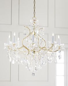 a chandelier hanging from the ceiling in a room with white walls and doors