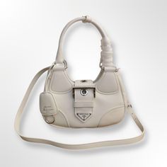 Classic retro return PASSAVELA element front, Nappa leather material, silver ring with pin buckle hardware embellishment, retro fashion to the extreme, the good-looking innovative soft design bag body is light and suitable for daily necessities, fashionable and playful in a new way. Softness and simplicity of the silhouette define this hobo Re-edition 2002 bag. Color: White. Soft Nappa leather. Nappa leather lining. Silver color metal hardware. Light padding. Triangular enameled-metal logo on strap. Hand carry double rounded Leather handles. Adjustable and detachable leather shoulder strap. Strap length: 100 cm. Removable leather key-chain. Magnetic closure. Inside zip pocket. Size: 22.5 × ... Padded Bag, Design Bag, Pad Bag, Soft Design, Daily Necessities, Metal Logo, Leather Key, Leather Keychain, Leather Handles