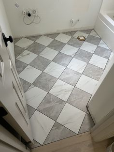 a white and grey tiled floor in a bathroom