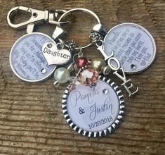 a keychain with two names on it and some charms attached to the back