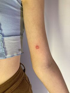 a woman's arm with a small red dot on the left side of her arm