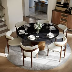 a dining room table with white chairs and plates on top of it in front of stairs