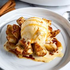 a white plate topped with waffles covered in ice cream and caramel sauce