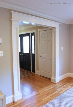 an empty living room with hard wood flooring and white trim on the door way