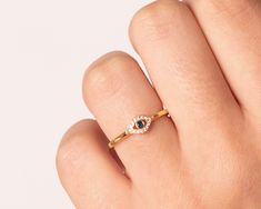 "Dainty & Minimalist Stacking ring with an Evil Eye with a round central sapphire cz and clear cz stones.  This ring is made of 18k gold plated 925 sterling silver and it's also available in 925 sterling silver. Details:  * Size of the eye: 8x5 mm /  * Hypoallergenic. Nickel free. Packaging:  All our jewelry comes in a white branded gift box, ready to gift. In case you buy more than 1 item, they will be packed to be as more ethical and sustainable possible to protect the jewelry and to save waste as much as possible.  Gift Wrapping Option:  The gift wrapping contains a white branded box for the jewelry that comes into a big box with wrapping paper and gift ribbon. It's perfect as a Mom gift, Bridesmaid gift, gift for women, birthday gift, gift for her or even to treat yourself. - Do you lo Diamond White Cubic Zirconia Sapphire Ring As Gift, Dainty Cubic Zirconia Sapphire Promise Ring, Lab-created Sapphire Rings With Diamond Accents As Gift, Gift Ribbon, Evil Eye Ring, Minimalist Gifts, Eye Ring, Stacking Ring, Ring For Women