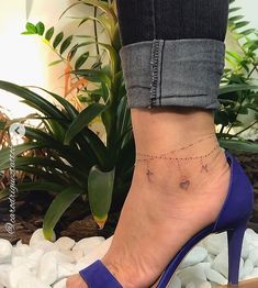 a woman's foot with a tiny heart tattoo on it