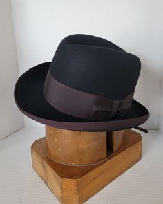 Elevate your style with this beautiful vintage Dobbs elegant homburg hat. Crafted from high-quality materials, this hat is the perfect addition to any wardrobe. With its classic design and versatile color, make it a must-have for any fashion-forward individual who wants to make a statement. Its timeless design and superior craftsmanship ensure that it will be a staple in your wardrobe for years to come. Invest in this vintage accessory today and add a touch of sophistication to your look. This b Classic Fitted Fedora Hat, Classic Fitted Felt Hat With Short Brim, Kentucky Derby Top Hat With Flat Bill, Classic Fitted Winter Hats, Fitted Hat For Formal Winter Occasions, Winter Fitted Flat Bill Hats, Winter Top Hat With Flat Brim, Winter Fitted Top Hat With Flat Brim, Fitted Winter Top Hat With Flat Brim