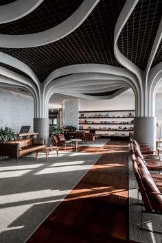 an empty lobby with wooden benches and chairs