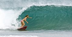 a woman riding a wave on top of a surfboard