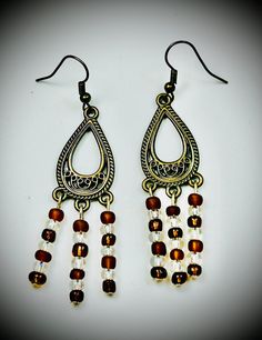 Elevate your style with these stunning Boho Chic Dangle Earrings, meticulously handcrafted to perfection. Featuring a unique vintage-inspired design, these earrings showcase a captivating teardrop motif adorned with intricate patterns. The cascading strands of high-quality Czech glass beads in rich amber and clear tones add a touch of elegance and movement to every step. Crafted with attention to detail, these earrings are perfect for any occasion, from casual outings to formal events. The light Silver Vintage Beaded Earrings With Dangling Beads, Bohemian Drop Earrings For Vintage Collection, Vintage Adjustable Jewelry With Dangling Beads, Bohemian Vintage Drop Earrings, Vintage Brown Dangle Jewelry, Handmade Metal Earrings For Vintage Collection, Handmade Vintage Drop Chandelier Earrings, Handmade Vintage Chandelier Earrings, Elegant Brown Earrings With Dangling Beads