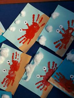 four handprints with clouds and eyes on them are displayed in front of blue paper