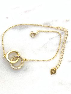 "✦DESCRIPTION ✦ Symbolizing the eternal bond of love, this 14kt yellow gold plated Sterling silver bracelet joins two interlocking open circles. Polished finish. Stationed on a cable chain. Spring ring clasp - Chain bracelet measurement is 7\" inch plus the 2\" inch extension. ✦Dear Customers ✦ We strive to provide the best quality with affordable prices. We take such pride in making sure to create unique, beautiful jewelry for all our Sioro Silver customers, and always seek to provide the very Gold Promise Bracelet, Adjustable Gold-plated Bracelet For Anniversary, Adjustable Gold Plated Bracelet For Anniversary, Elegant Tarnish Resistant Charm Bracelet For Anniversary, Adjustable Tarnish Resistant Chain Bracelet For Anniversary, Elegant Gold-tone Bracelets For Valentine's Day, Elegant Gold-tone Bracelet For Valentine's Day, Gold Charm Bracelet With Adjustable Chain For Anniversary, Anniversary Metal Bracelet With Adjustable Chain