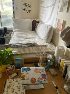 a bed room with a neatly made bed and lots of clutter on the desk