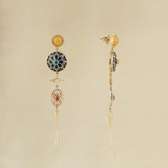 India-inspired, the Firdos earrings are a nod to 1940s Hollywood style, when chandelier earrings were a 'big thing'. These earrings bring together, in harmony, handcrafted units, each unique in themselves. Highlights of the story being an intricately enamelled - diamond studded disc and an ornate pearl strung oval-shaped disc. They are all held together by a bright yellow stud and a push-back closure. Gold(14K) : 9.51gRose-cut Diamonds : 0.95ctGemstone : Emerald, Ruby, Yellow Onyx, Cultured Pear Round Chandelier Earrings In Fine Jewelry Style, Round Chandelier Earrings Fine Jewelry, Fusion Style Multi-stone Yellow Gold Earrings, Exquisite Yellow Gold Earrings With Gemstone Accents, Yellow Gold Multi-stone Fusion Earrings, Gold-plated Yellow Gold Earrings With Gemstone Accents, Fusion Style Yellow Gold Earrings With Gemstone Accents, Fusion Yellow Gold Earrings With Gemstone Accents, Exquisite Multi-stone Gold Earrings