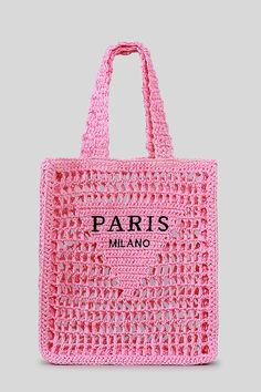 a pink crocheted bag with the word paris printed on it's side