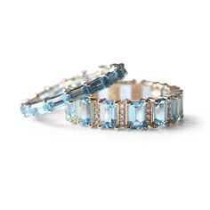 Gorgeous blue topaz eternity band with set in 14K gold. These rings are beautiful on their own or for extra wow factor stack with other colors! Topaz is the birthstone for the month of November and is known to exude calming energies while symbolizing love, affection, and strength while deepening one's sense of self. Please have your finger sized professionally by your local jeweler prior to placing your order as all sales are final. If you are not confident in your ring size, we suggest sizing u Emerald Cut Eternity Band, Eternity Band Set, Month Of November, Diamond Choker, Dope Jewelry, Yellow Citrine, Topaz Stone, Wow Factor