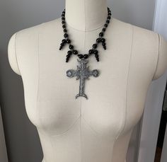 This beautiful, one-of-a-kind pewter ornate cross necklace will inspire all your moonlit nights. Handmade with black agate and glass beads. Measures 18 inches long and has a 2 inch extender chain. product details silver tone metals; Cross is soft pewter. 18 inches long with 2 inch extender black agate and glass beads VISIT MY SHOPS HERE * http://www.etsy.com/shop/HappyCatHouse * http://www.Etsy.com/shop/AnEnchantingCreature CONNECT * http://www.facebook.com/EnchantingCreature * https://www.insta Gothic Cross Pendant Jewelry For Halloween, Gothic Black Cross Pendant Necklace, Silver Ankh Gothic Necklace, Gothic Metal Cross Necklaces, Gothic Metal Cross Necklace, Gothic Cross Necklaces For Jewelry Making, Black Gothic Necklaces For Larp, Gothic Silver Crucifix Necklace, Silver Gothic Crucifix Necklace