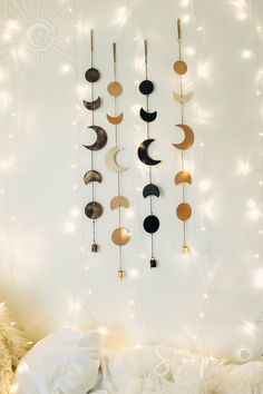 a white bed topped with pillows next to a wall covered in lights and moon decorations