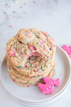 a stack of cookies sitting on top of a white plate with sprinkles