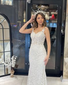 a woman in a wedding dress posing for the camera with her hand on her head