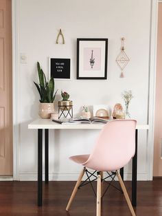 a white desk topped with a laptop computer next to a plant