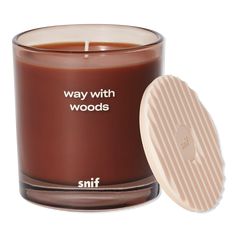 a brown candle with the words, way with woods on it next to a white lid