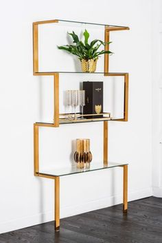 a shelf with some books and vases on it in the corner of a room