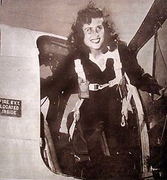 an old black and white photo of a woman sitting in a plane