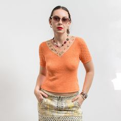 Vintage short sleeve top in orange - made of stretchy knitted fabric - openwork sleeves - neckline embellished with lace and beads - material: 50% cotton, 30% elastane, 20% viscose SIZE from the tag: no tag  Best fits women: M MEASUREMENTS (The blouse is made of stretchy material. The measurements were taken while the garment was lying flat) bust: 33 inches (84 cm) length: 21 inches (53 cm) The model is 5'9" (174 cm), measures 35-27-38 (90-69-96 cm) and typically wears clothing in size M CONDITI Orange V-neck Knit Top, Fitted V-neck Crochet Top With Pointelle Knit, Fitted Lace Top T-shirt For Spring, Elegant Fitted V-neck Crochet Top, Fitted Pointelle Knit Short Sleeve Top, Orange Knit V-neck Top, Stretch Lace Top With Short Sleeves, Orange V-neck T-shirt For Summer, Stretch Pointelle Knit Short Sleeve Top