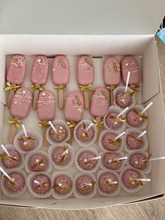 a box filled with pink and gold desserts