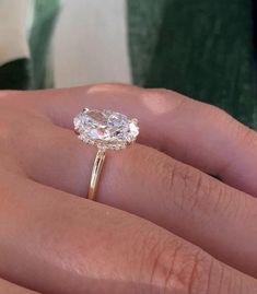 a woman's hand with a ring on it and a diamond in the middle