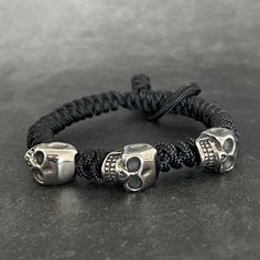 Each paracord bracelet features 3 stainless steel skull beads and is fully adjustable. It is perfect to add to a bracelet stack. The primary colour selection will be the main colour of the bracelet. The secondary colour is the micro cord which is woven over the end to secure the bracelet. For wrist size please measure your wrist with a tape measure and do not allow any slack or gaps in the tape. Please then select this as the size option. For other customised orders please do get in touch. Black Skull Bracelets For Streetwear, Gothic Adjustable Bracelet For Streetwear, Adjustable Gothic Bracelet For Streetwear, Adjustable Silver Bracelet For Streetwear, Adjustable Gothic Bracelets With Skull Print, Gothic Silver Adjustable Wristband, Gothic Style Adjustable Silver Wristband, Gothic Adjustable Silver Wristband, Silver Gothic Adjustable Wristband