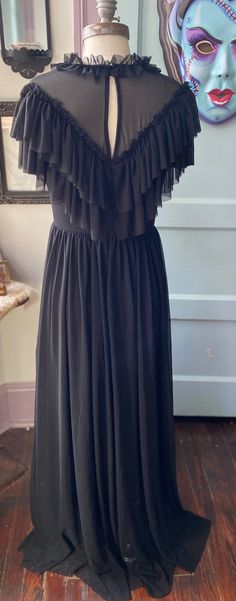 Meet Mina! The most romantic and dramatic Victorian gothic dress of your dreams! This dress is made out of over 5 yards of soft, buttery mesh, with a double layer ruffled neckline and a deep, plunging v neck at the front at the back. The back neck also has a keyhole cutout with a dainty button, and this entire dress is Ruffled V-neck Maxi Dress For Gala, Evening Dresses With Ruffles And Empire Waist, Empire Waist Ruffle Evening Dress, Flowy Evening Maxi Dress With Ruffled Skirt, Evening V-neck Maxi Dress With Ruffles, Flowy Tiered Ruffle Dress For Evening, Flowy Evening Dress With Ruffled Straps, Evening Ruffle Dress With Ruffled Straps, Black Maxi Dress With Ruffled Straps