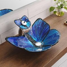 a blue glass bird sitting on top of a wooden table